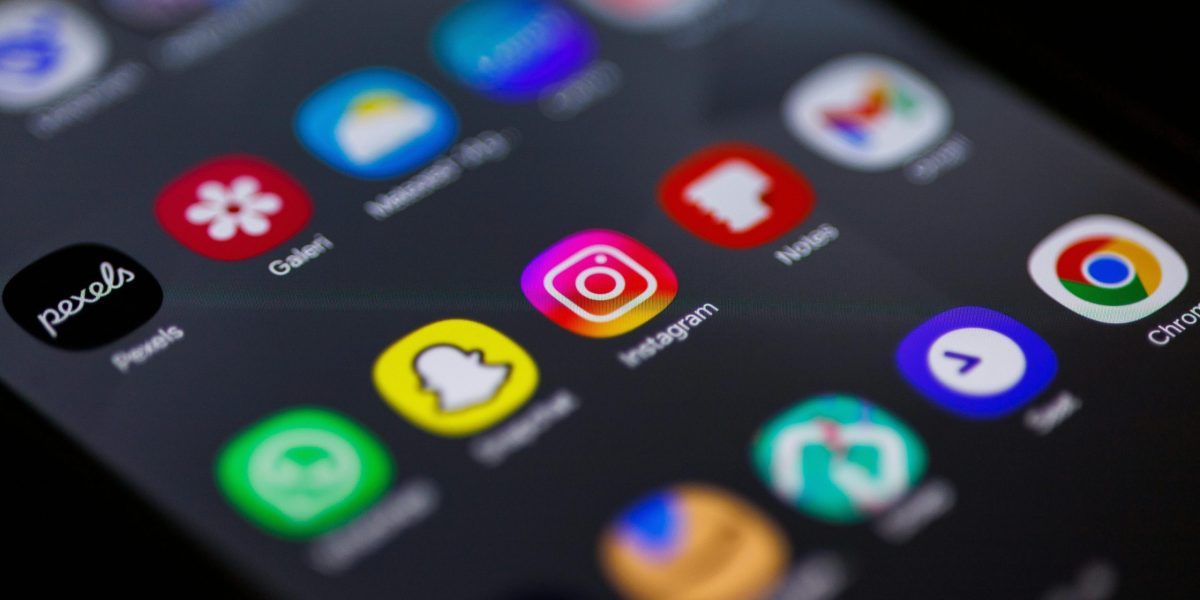 Close-up view of smartphone home screen featuring popular apps like Instagram, Snapchat, and Chrome.
